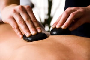 woman getting a hot stone massage at a day spa